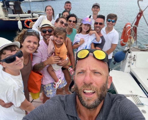 Ospiti si rilassano prendendo il sole a bordo della barca a vela all'Asinara.