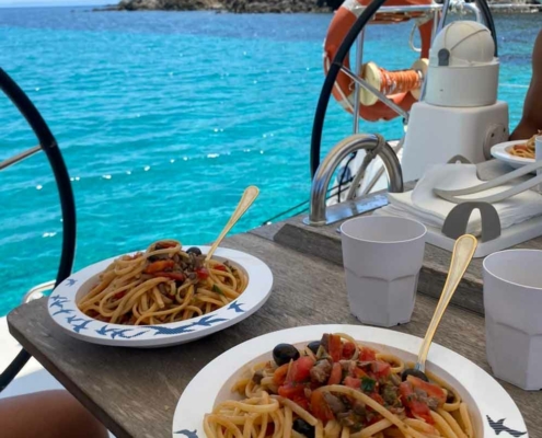 Piatto di pasta con frutti di mare servito a bordo durante il pranzo dell'escursione.